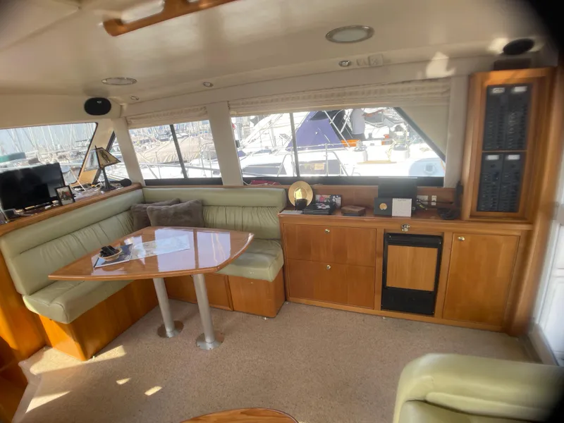 Slide: The Image of Interior of 2000 Riviera Flybridge yacht with seating, table, and cabinetry. - 2