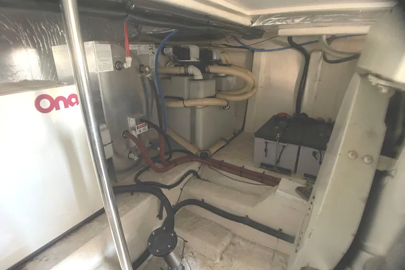 Slide: The Image of Engine room of a 2000 Riviera Flybridge boat, showcasing mechanical components and wiring. - 23