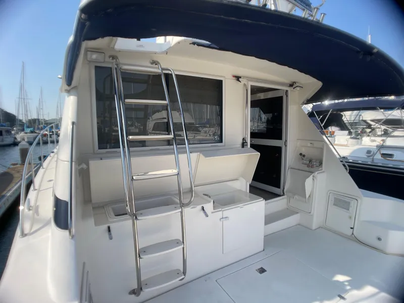 Slide: The Image of 2000 Riviera Flybridge yacht with ladder and seating area in marina. - 24