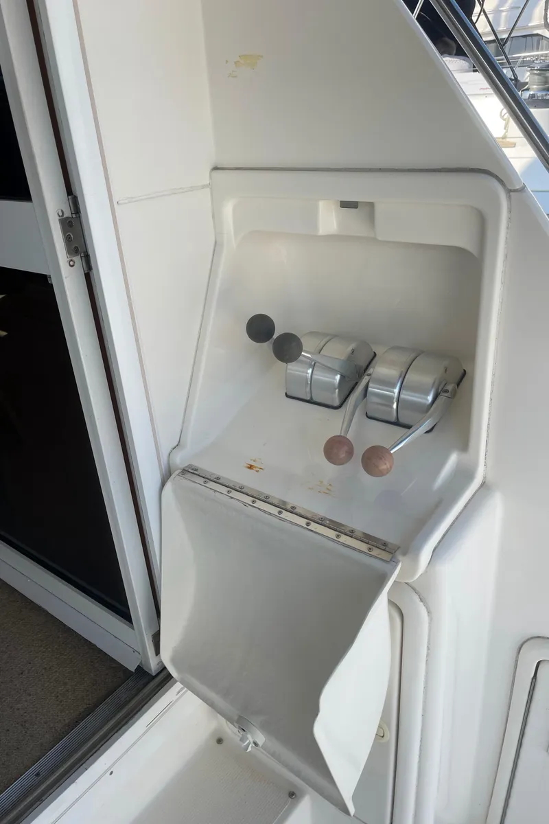 Slide: The Image of Control panel on a 2000 Riviera Flybridge yacht, featuring throttle levers and switches. - 25