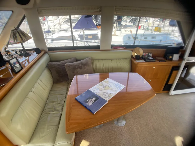 Slide: The Image of Interior of 2000 Riviera Flybridge yacht with plush seating and wooden table. - 3