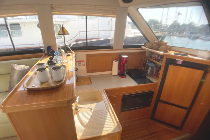 Slide: The Image of Interior of 2000 Riviera Flybridge yacht with kitchenette and wooden cabinetry. - 4