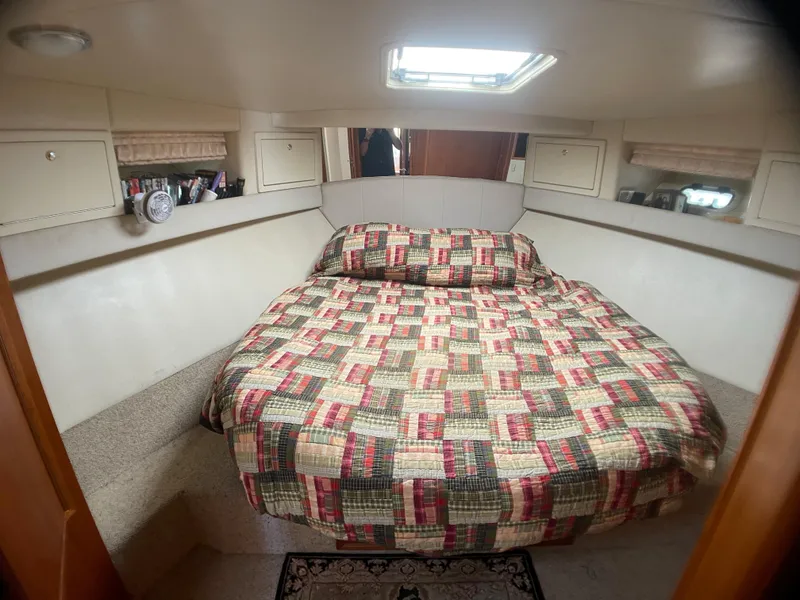 Slide: The Image of Cozy bedroom in 2000 Riviera Flybridge yacht with patterned quilt and overhead skylight. - 5