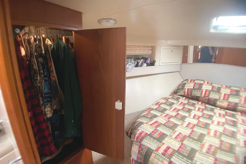 Slide: The Image of Interior of 2000 Riviera Flybridge yacht with cozy bedroom and open closet. - 7