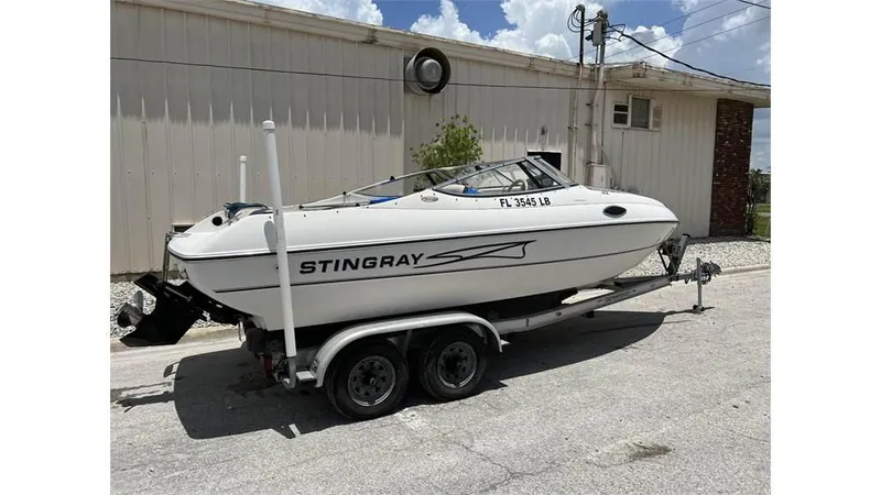 Slide: The Image of 1999 Stingray 200 CS/CX boat on a trailer, parked outdoors. - 11