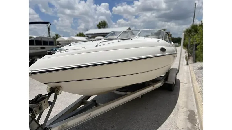 Slide: The Image of 1999 Stingray 200 CS/CX boat on a trailer under a partly cloudy sky. - 17