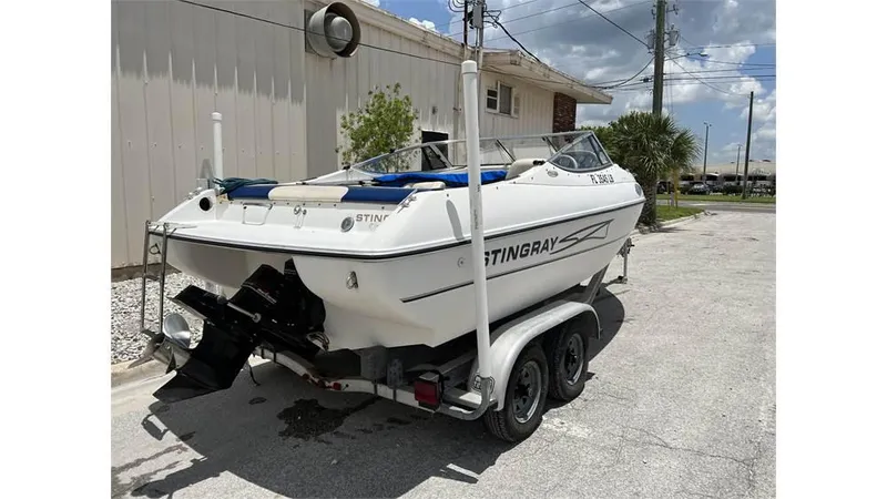 Slide: The Image of 1999 Stingray 200 CS/CX boat on a trailer, parked outdoors. - 2