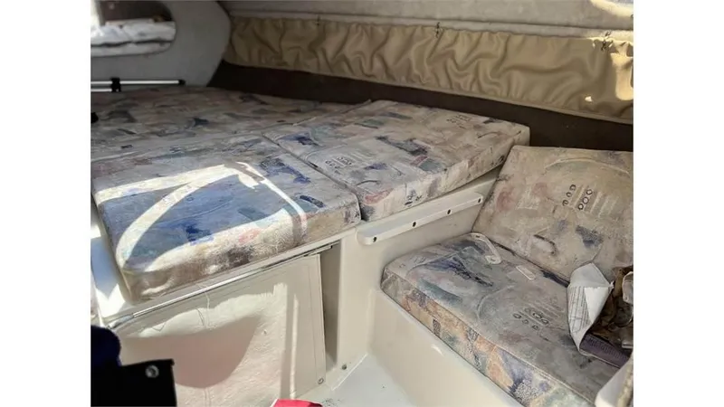 Slide: The Image of 1999 Stingray 200 CS/CX boat interior cabin with cushioned seating and sleeping area. - 3