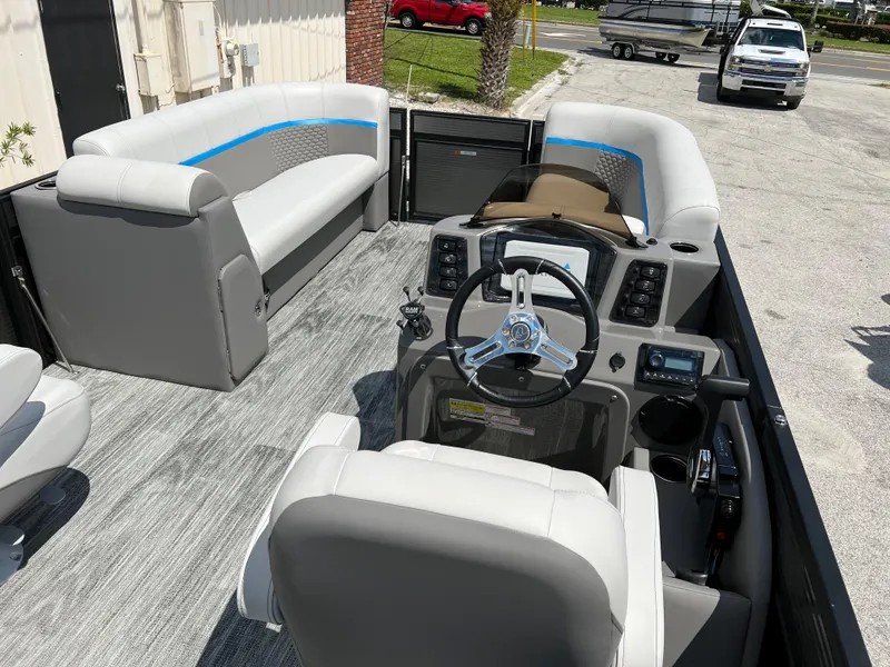 Slide: The Image of 2024 Qwest Splash Pad 822 pontoon boat interior with gray seating and modern dashboard. - 10