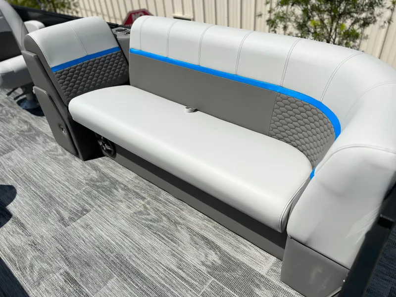 Slide: The Image of 2024 Qwest Splash Pad 822 boat interior with gray and blue cushioned seating. - 13