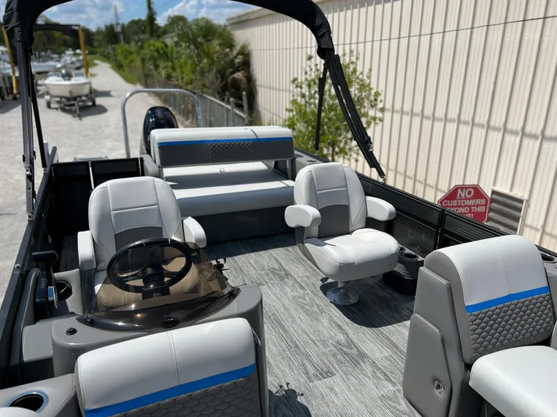 Slide: The Image of 2024 Qwest Splash Pad 822 pontoon boat interior with seating and steering console. - 17
