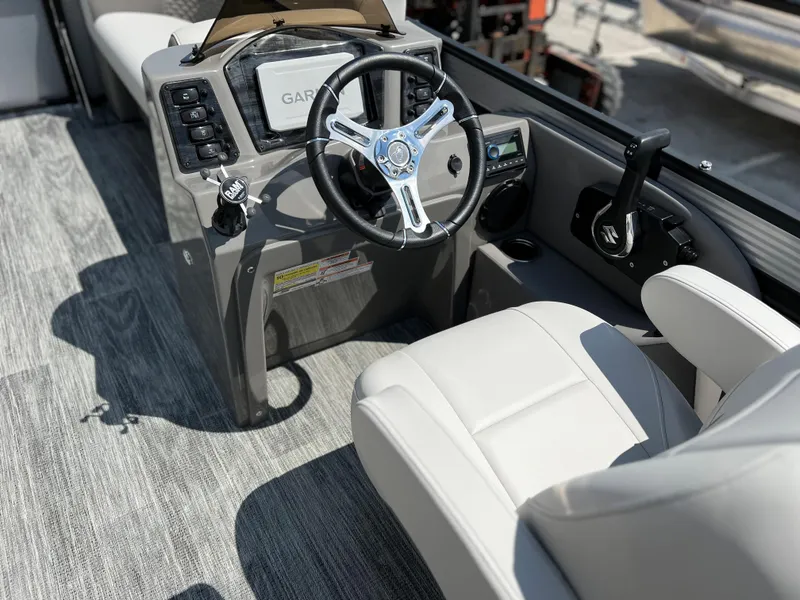 Slide: The Image of 2024 Qwest RLS 820 boat cockpit with steering wheel and Garmin navigation system. - 12