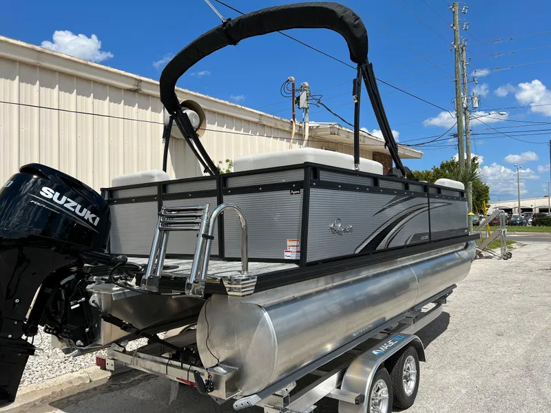 Slide: The Image of 2024 Qwest RLS 820 pontoon boat with Suzuki outboard motor on trailer. - 2