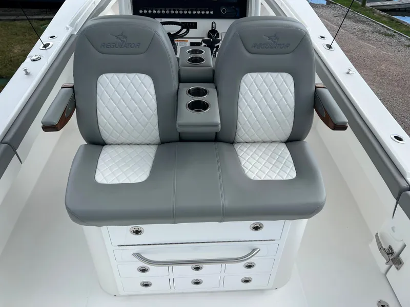 Slide: The Image of 2024 Regulator 31 boat with dual cushioned seats and storage drawers. - 16