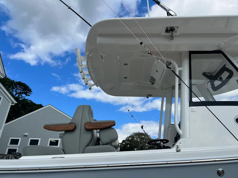 Slide: The Image of 2024 Regulator 31 boat with fishing rods and seating under a blue sky. - 20