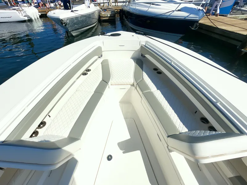 Slide: The Image of 2024 Regulator 31 boat interior with white cushioned seating at a marina. - 21
