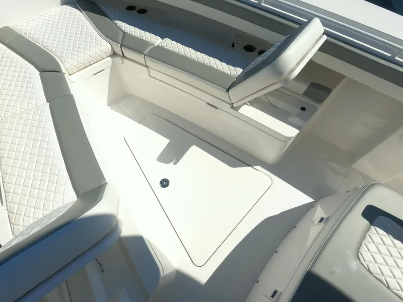 Slide: The Image of 2024 Regulator 31 boat interior with cushioned seating and storage compartments. - 25