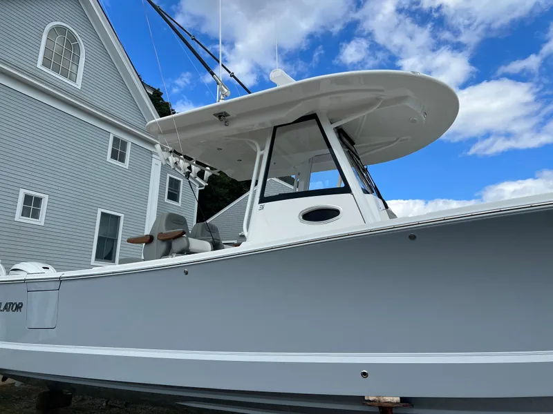 Slide: The Image of 2024 Regulator 31 boat docked near a gray building under a blue sky. - 4