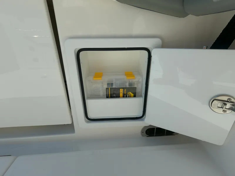 Slide: The Image of Storage compartment on 2024 Regulator 31 boat with a clear plastic container inside. - 42