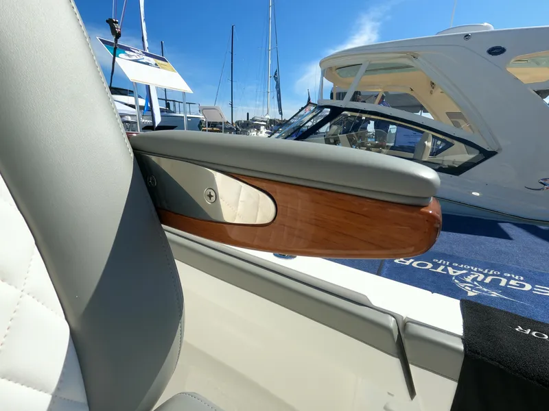 Slide: The Image of 2024 Regulator 31 boat interior detail with luxurious armrest and marina background. - 43