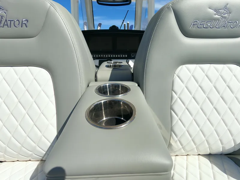 Slide: The Image of 2024 Regulator 31 boat interior with white quilted seats and dual cup holders. - 45