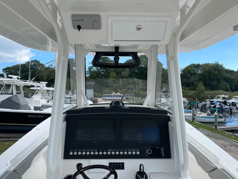 Slide: The Image of 2024 Regulator 31 boat dashboard and controls at a marina. - 7