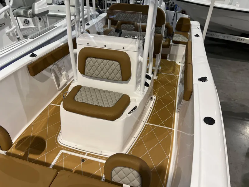 Slide: The Image of 2024 Clearwater 2000 boat interior with tan and white seating and diamond-patterned cushions. - 16