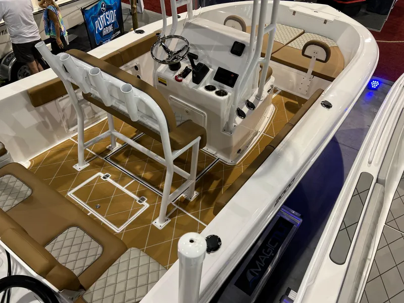 Slide: The Image of 2024 Clearwater 2000 boat interior with tan and white seating, steering console, and rod holders. - 18