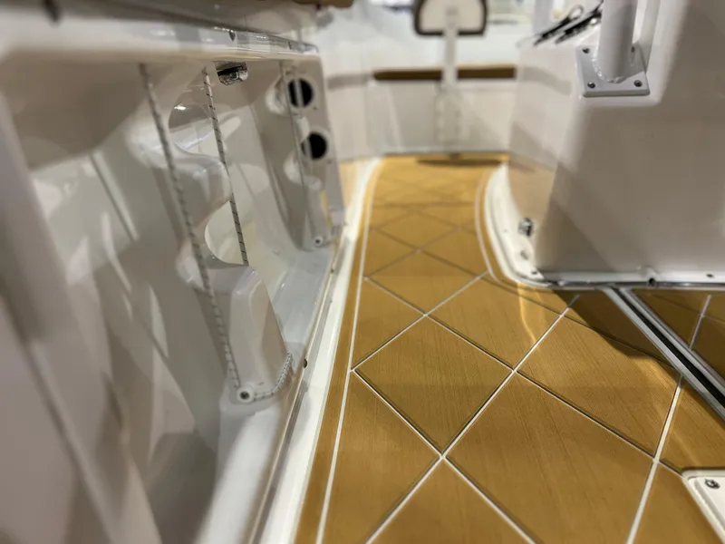 Slide: The Image of Clearwater 2000 boat interior, 2024 model, featuring teak flooring and white storage compartments. - 7