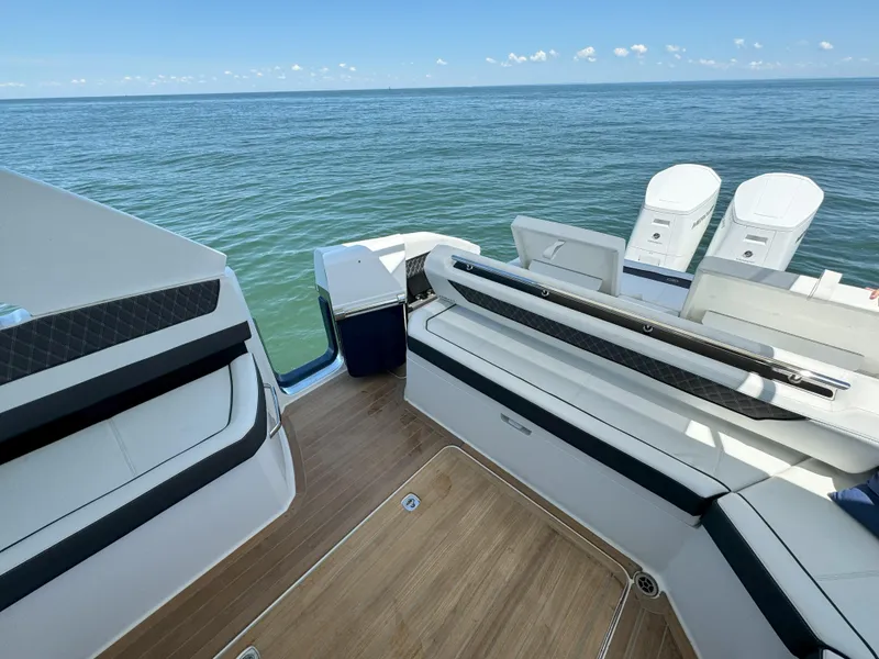 Slide: The Image of 2024 Cobalt R35 Outboard boat with spacious deck and twin engines on open water. - 12