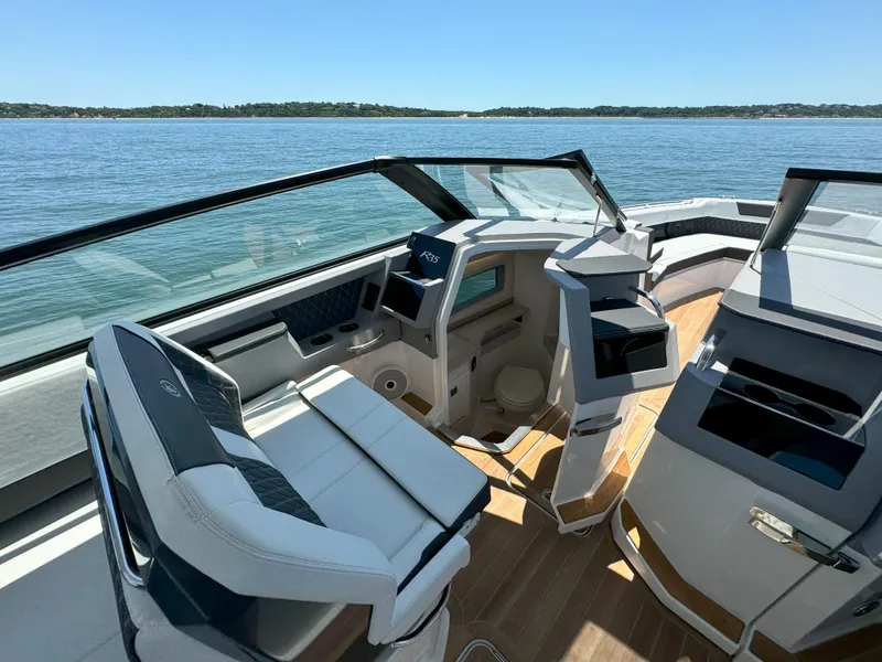 Slide: The Image of 2024 Cobalt R35 Outboard boat interior with luxurious seating and modern dashboard on a sunny day. - 13