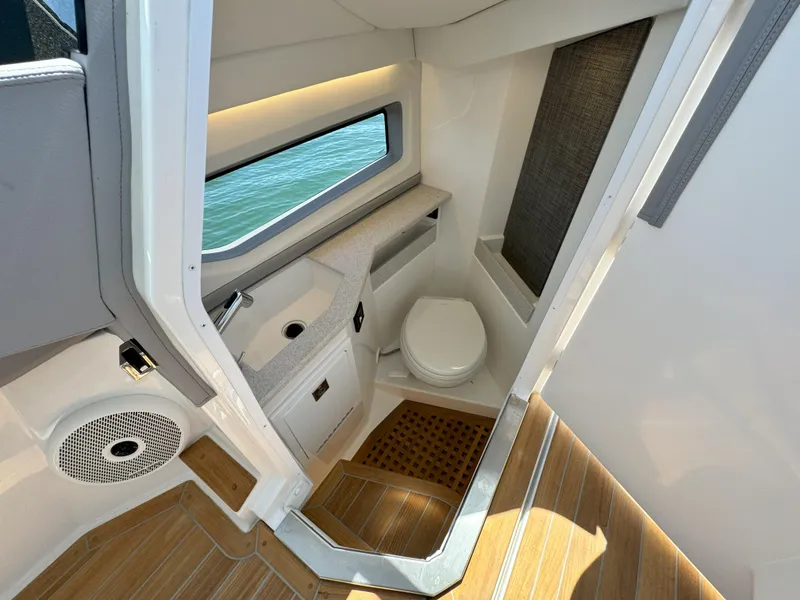 Slide: The Image of 2024 Cobalt R35 Outboard boat interior bathroom with modern amenities and wooden flooring. - 14