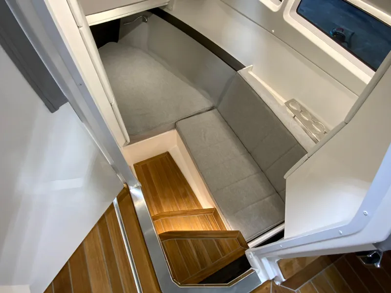 Slide: The Image of 2024 Cobalt R35 Outboard cabin interior with wooden steps and grey seating. - 21
