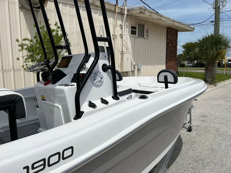 Slide: The Image of 2024 Clearwater 1900 boat, white exterior, docked near a building. - 21