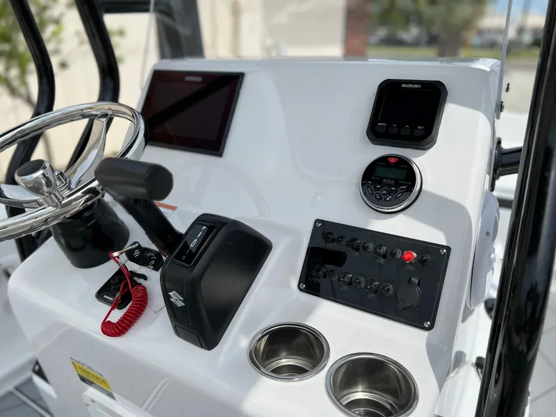 Slide: The Image of Clearwater 1900 2024 boat console with steering wheel, controls, and cup holders. - 7