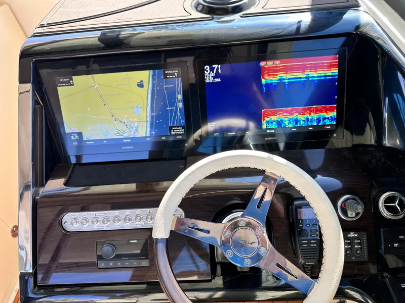 Slide: The Image of 2021 Chris-Craft Calypso 35 dashboard with dual navigation screens and steering wheel. - 18