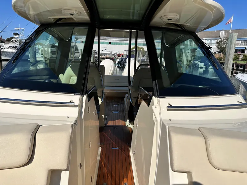 Slide: The Image of 2021 Chris-Craft Calypso 35 boat interior with teak flooring and beige seating. - 26