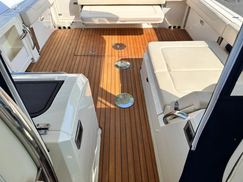 Slide: The Image of 2021 Chris-Craft Calypso 35 boat interior with teak flooring and white seating. - 40
