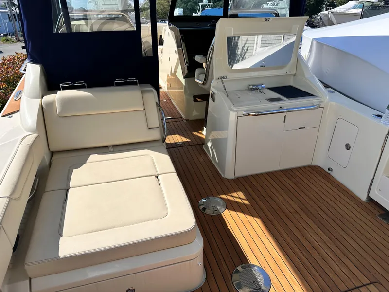 Slide: The Image of 2021 Chris-Craft Calypso 35 boat interior with beige seating and wooden deck. - 42