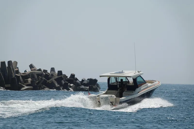 Slide: The Image of 2021 Chris-Craft Calypso 35 boat cruising near rocky shoreline. - 6