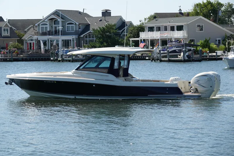 Slide: The Image of 2021 Chris-Craft Calypso 35 boat cruising near waterfront homes. - 8