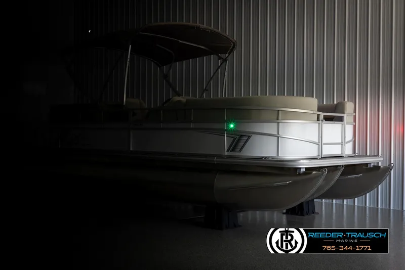 Slide: The Image of 2024 SunChaser Vista 22 LR pontoon boat in a dimly lit storage area. - 4