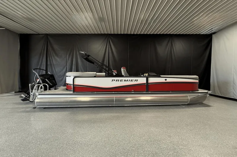 Slide: The Image of 2024 Premier 250 Solaris pontoon boat in showroom, featuring sleek red and silver design. - 0