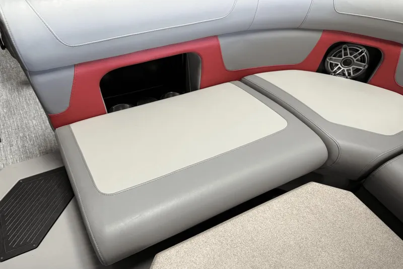 Slide: The Image of 2024 Premier 250 Solaris boat interior with gray and red seating, speaker, and storage compartment. - 19