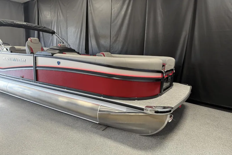Slide: The Image of 2024 Premier 250 Solaris pontoon boat with red and gray design in showroom. - 3