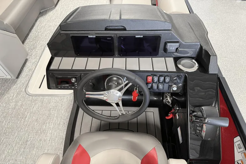 Slide: The Image of 2024 Premier 250 Solaris boat dashboard with steering wheel, controls, and dual Simrad displays. - 32