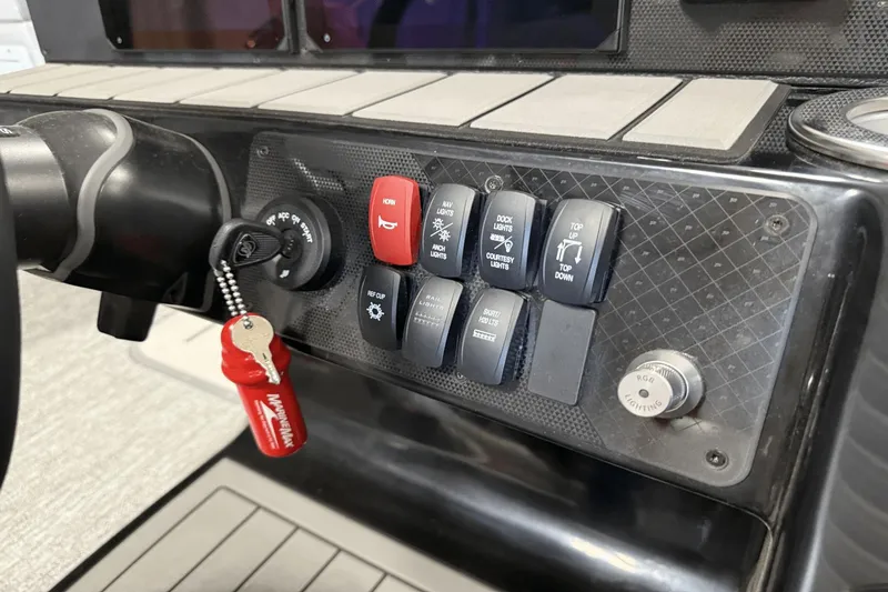 Slide: The Image of Control panel of 2024 Premier 250 Solaris boat with ignition key and switches. - 34