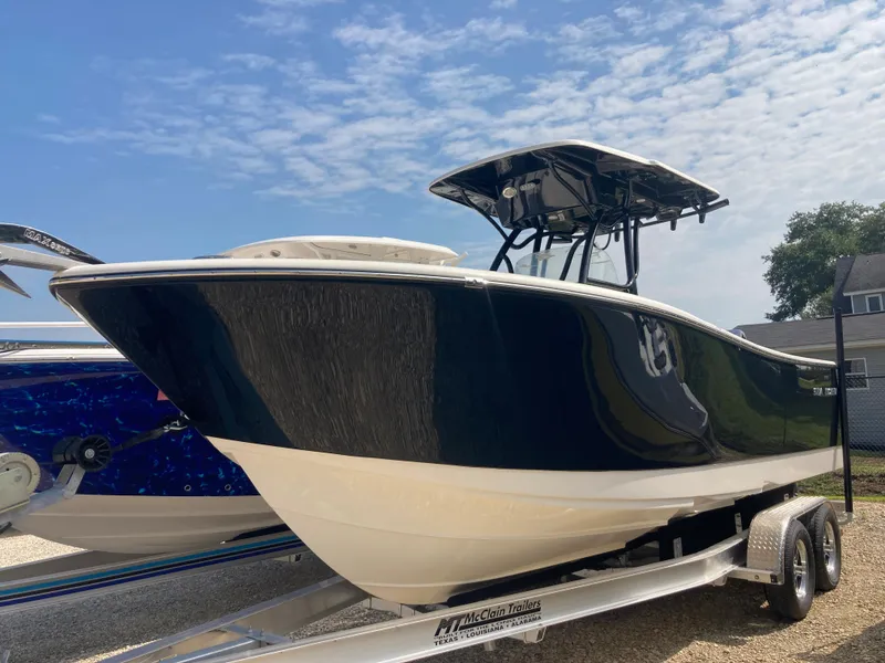 The Image of 2024 Sea Born SX239 Offshore boat on trailer under blue sky. - 1