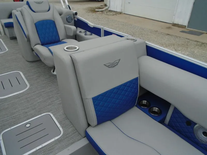Slide: The Image of 2024 Bennington 23 LTFB boat interior with gray and blue seating, cup holders, and speakers. - 17