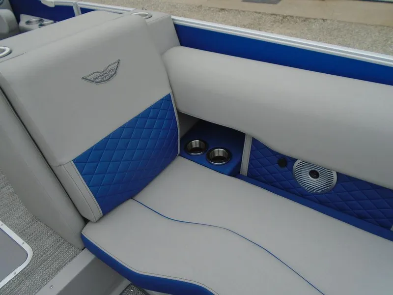 Slide: The Image of 2024 Bennington 23 LTFB boat interior with blue and gray seating, cup holders, and speaker. - 20